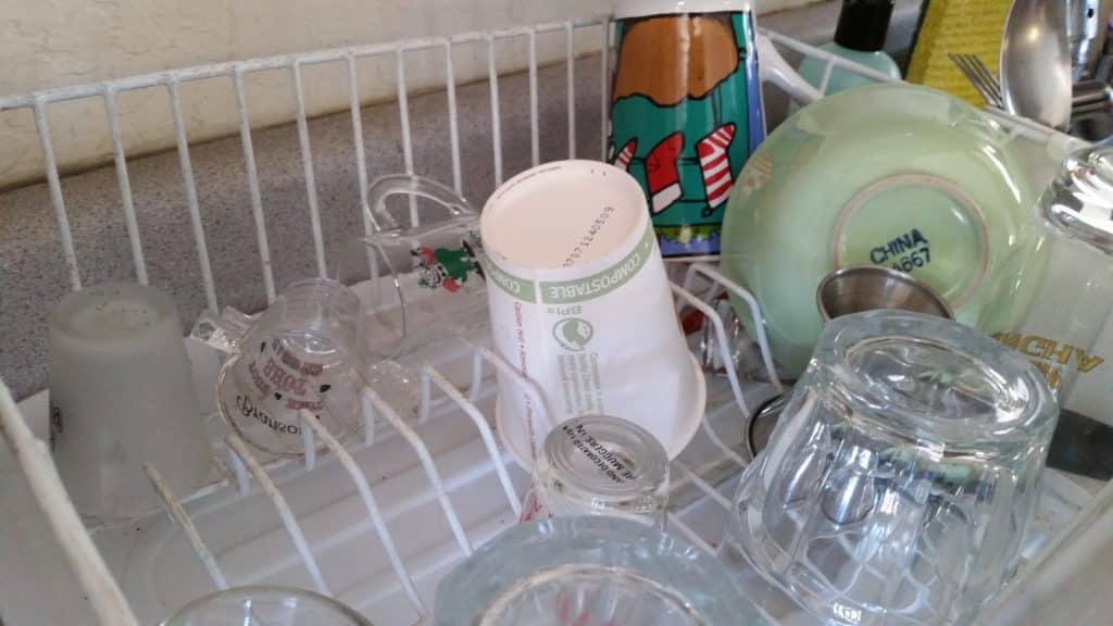 A disposable paper cup sitting in a dish draining rack