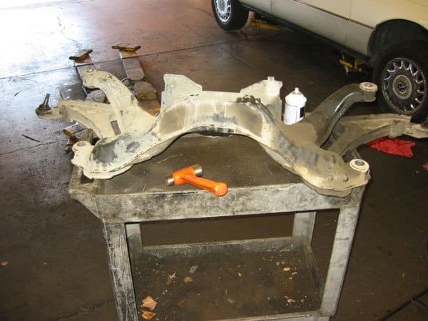 subframe removed from car sitting on a cart