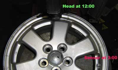 Wheel on tire machine with marking showing that the TPMS sensor should be 3:00 when the head is at 12:00