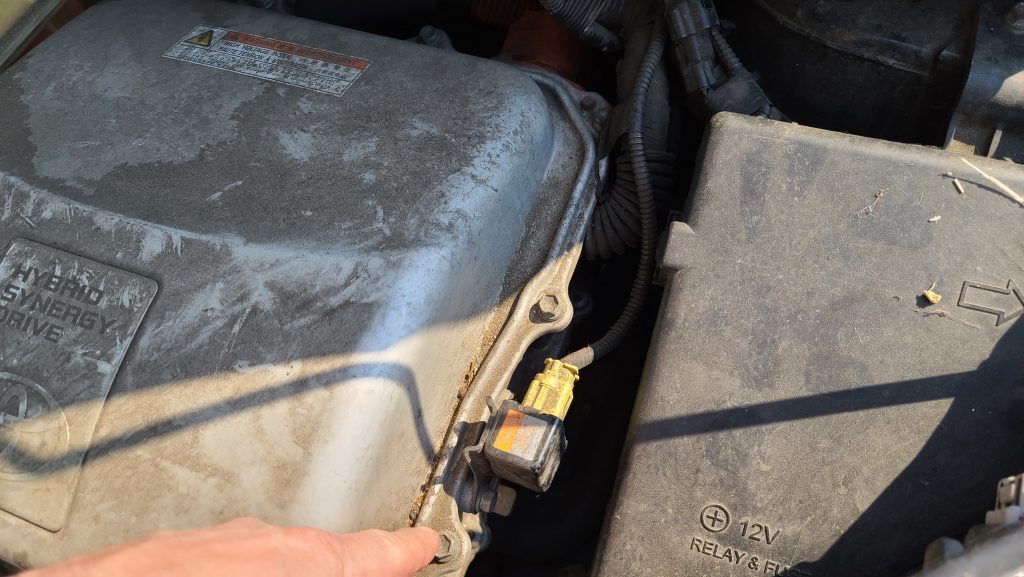 Connecting the ground clamp to the inverter cover to jump start a 2004-2009 prius