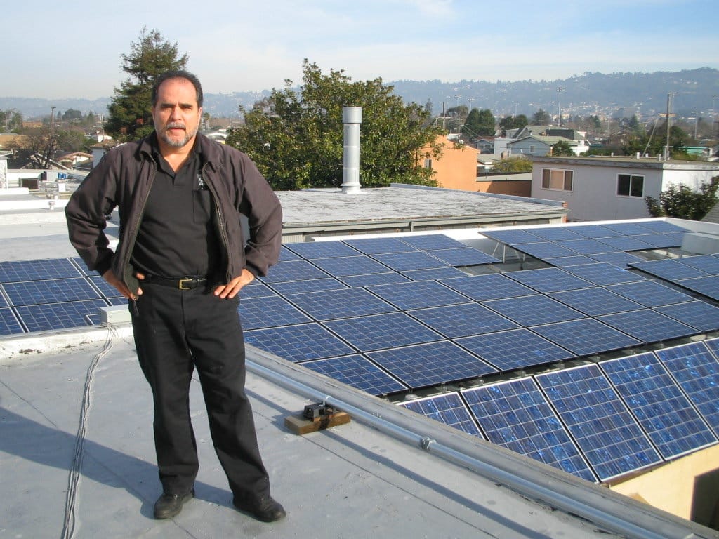 Art standing on roof in front of the new solar power system