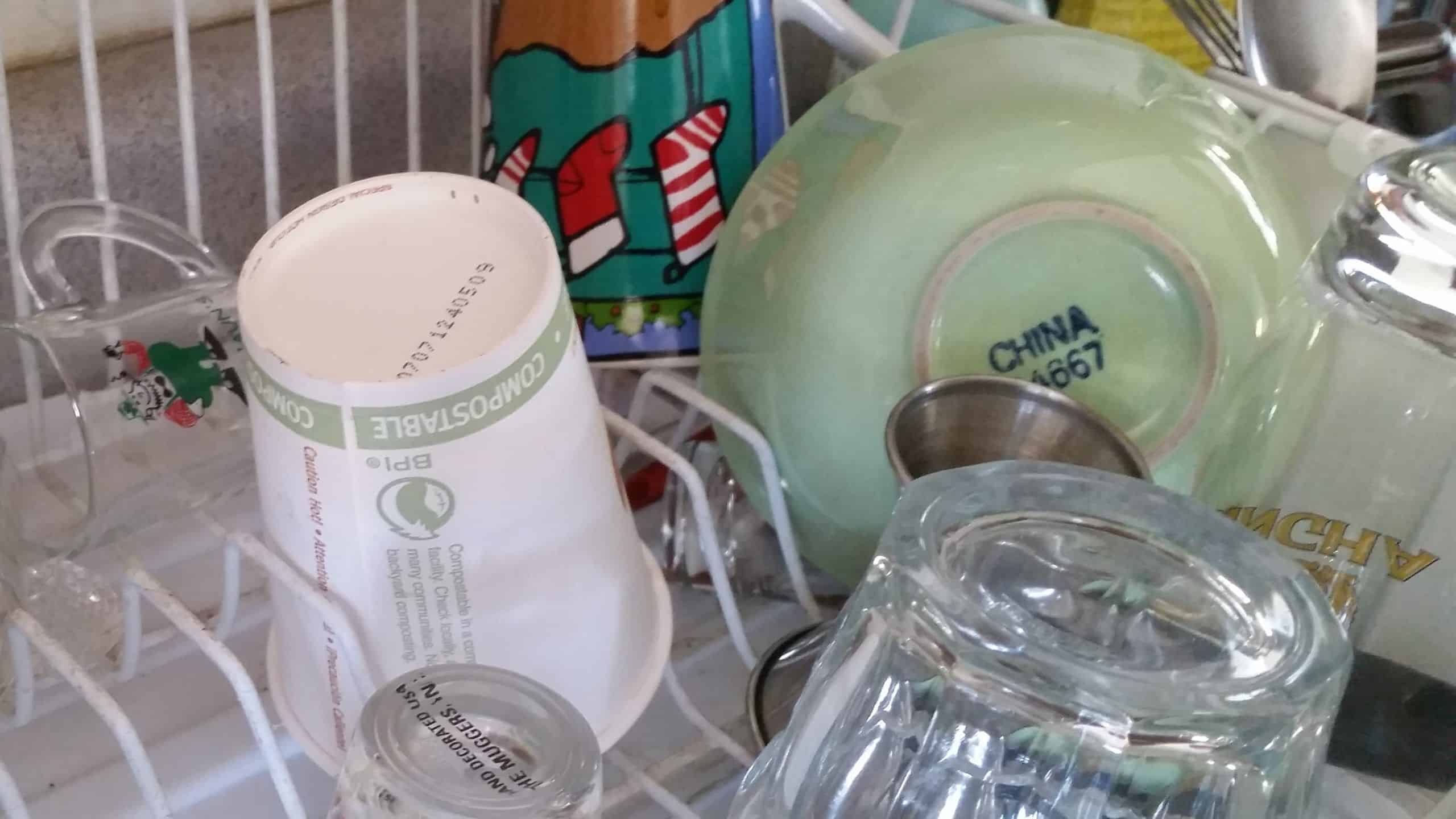 A disposable paper coffee cup sitting in a dish draining rack