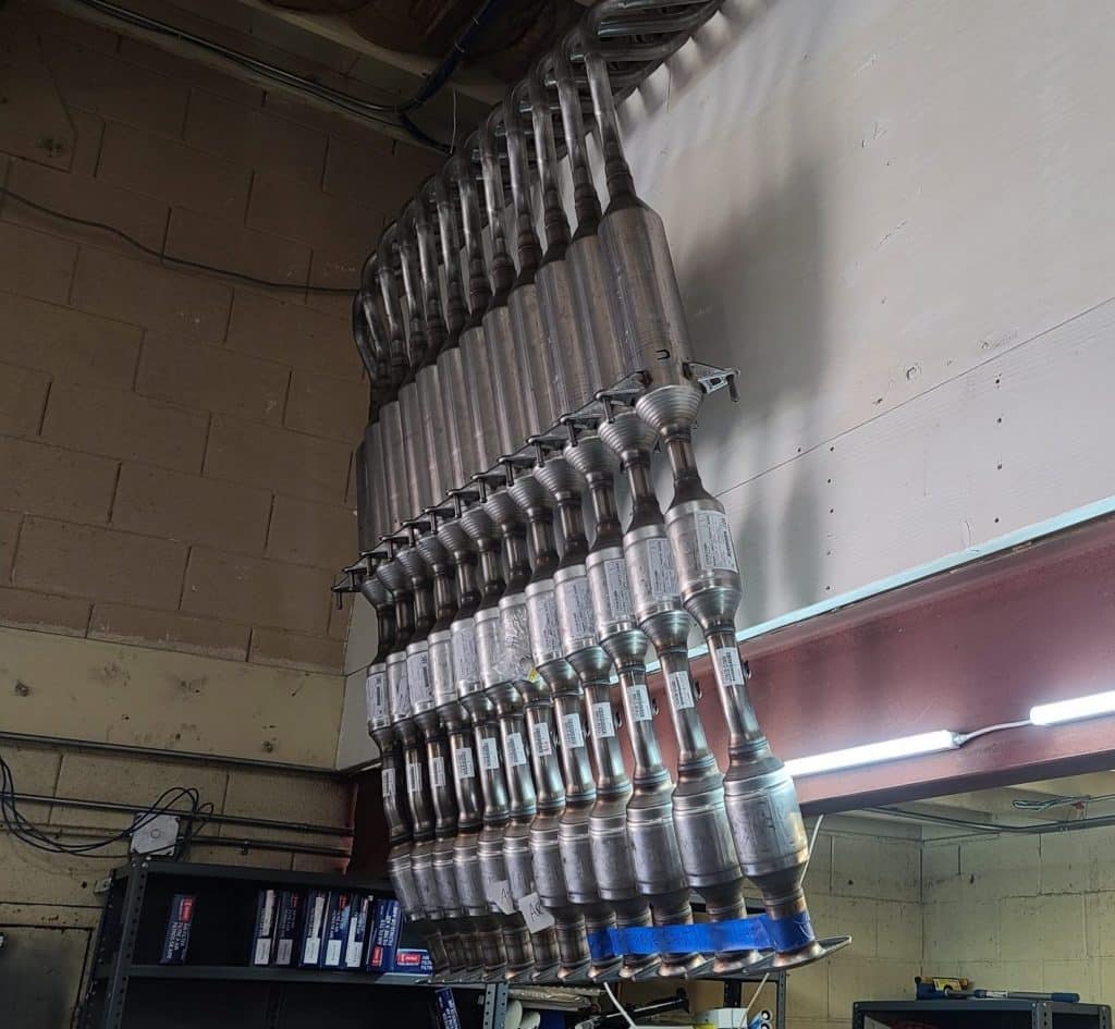 12 new Prius catalytic converters hanging neatly on the wall