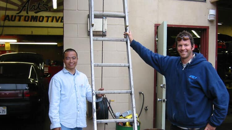 Two solar technicians posing with a ladder