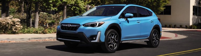 An image of a blue Subaru Crosstrek hybrid driving on a street