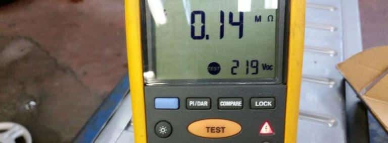 insulation test meter displaying 0.14 megohms sitting on a 2002 prius battery