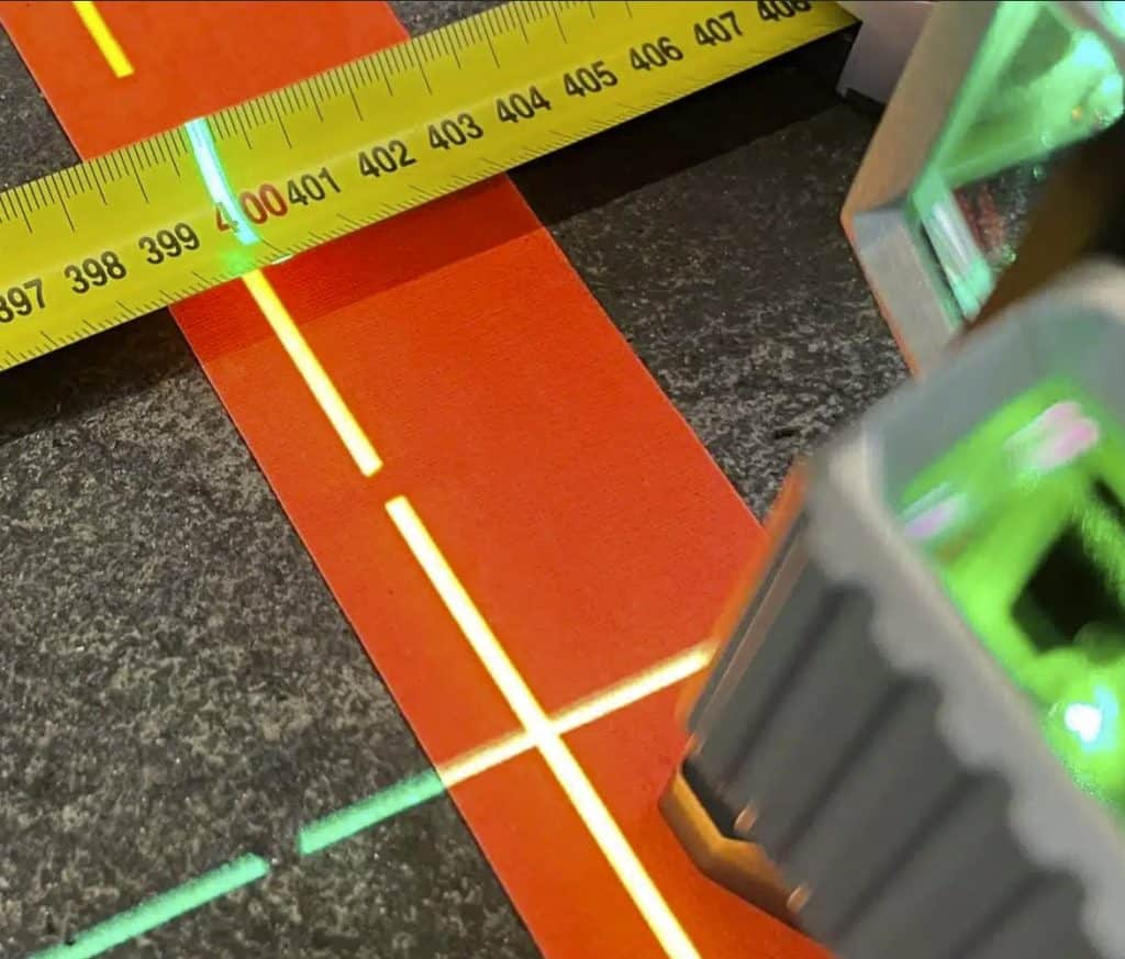 Lines from a laser level and and tape measure on the floor.