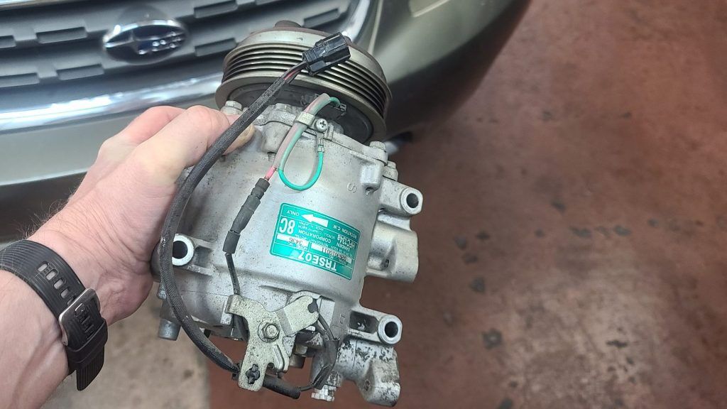 Subaru ac compressor removed during repair car repair.