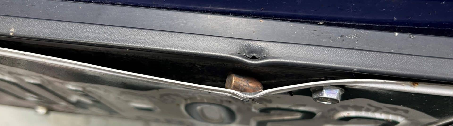 A mostly intact 9mm bullet that fell from the sky embedded in a license plate