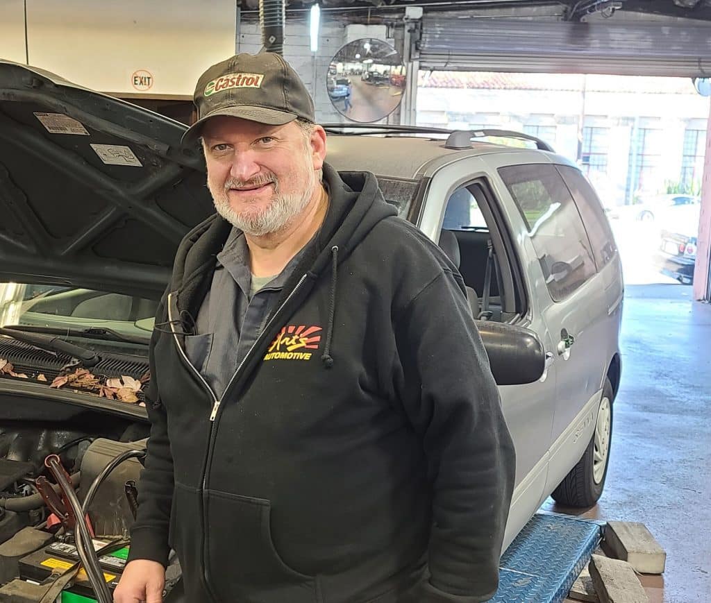 Brad standing next to a Toyota Sienna minivan with the hood up