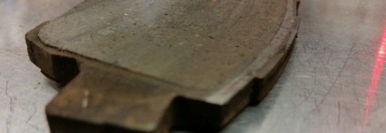 A close inspection of a worn out brake pad.