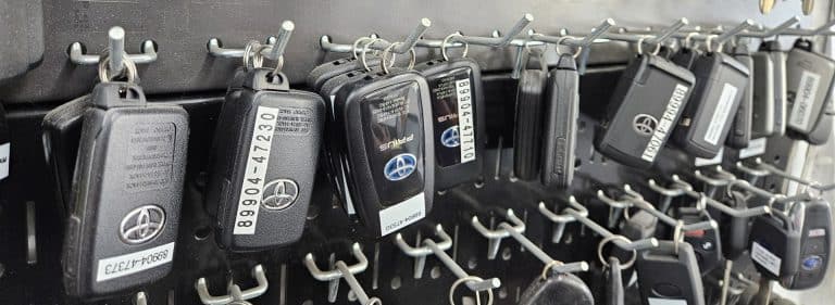 A row of replacement car keys hanging on a board.