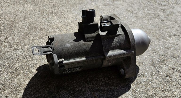A starter motor removed from a vehicle because it was making a clicking noise.