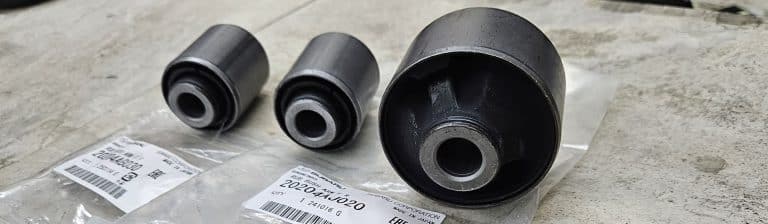 Three new control arm bushings sitting on shelf
