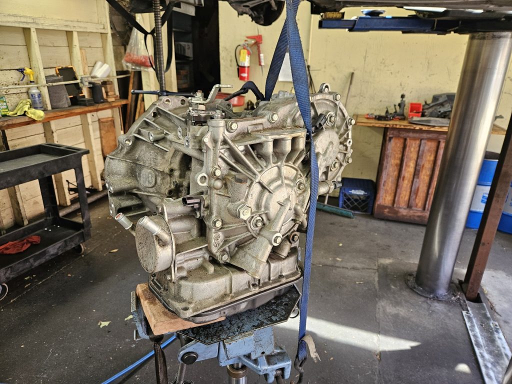 A used Toyota CVT removed from a car on a transmission jack.