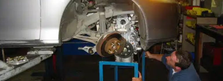 A mechanic replacing a Honda engine.