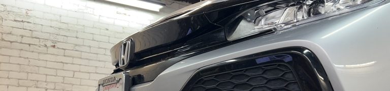 A banner image with a Honda on a lift being repaired.