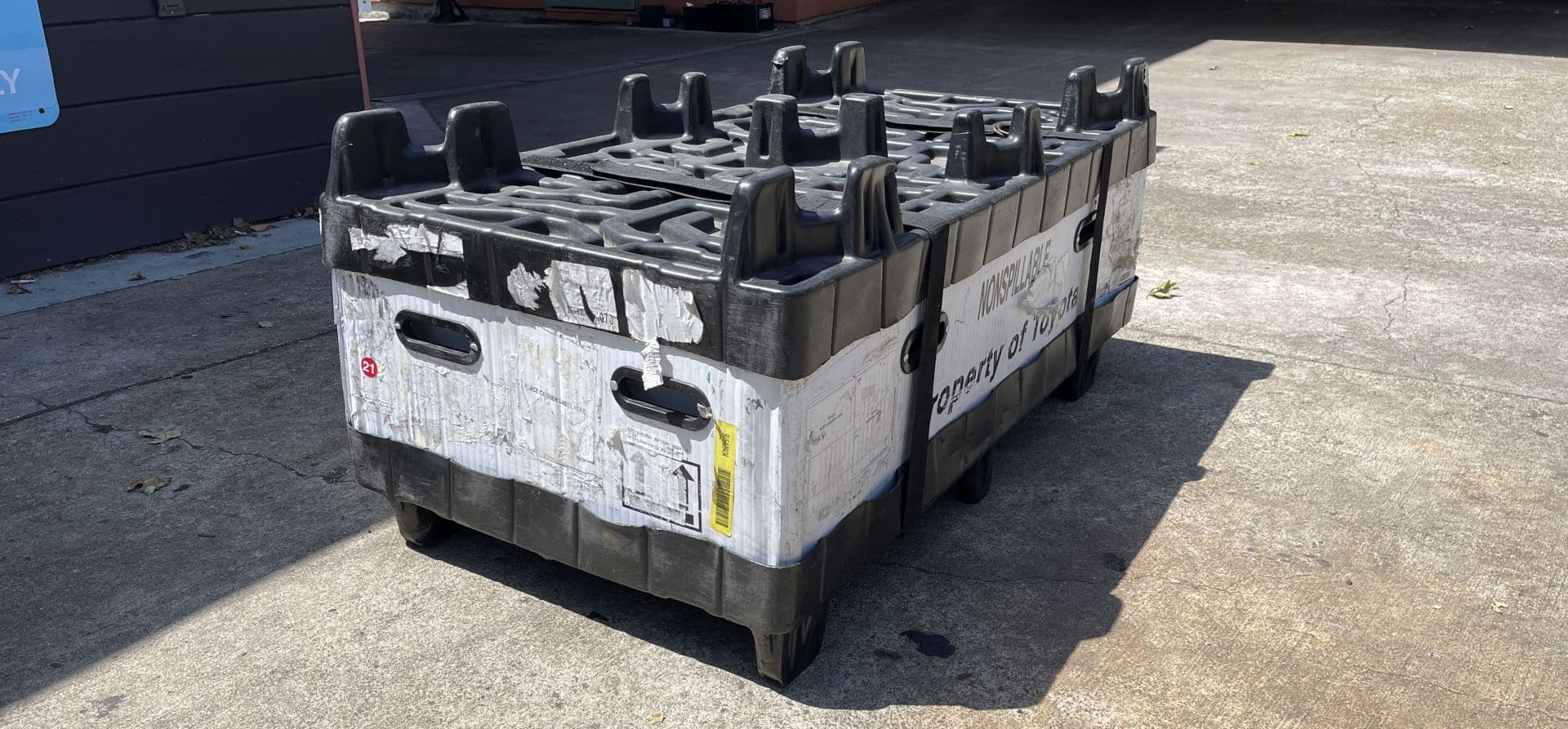 A reusable Toyota hybrid battery container sitting on the floor.