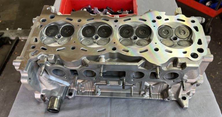A freshly machined cylinder head sitting on a bench