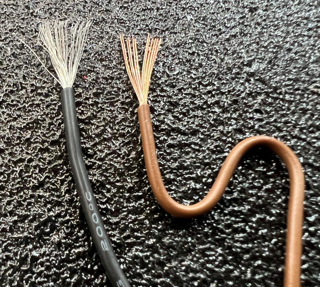A fine strand wire next to a inflexible wire bent in an S shape
