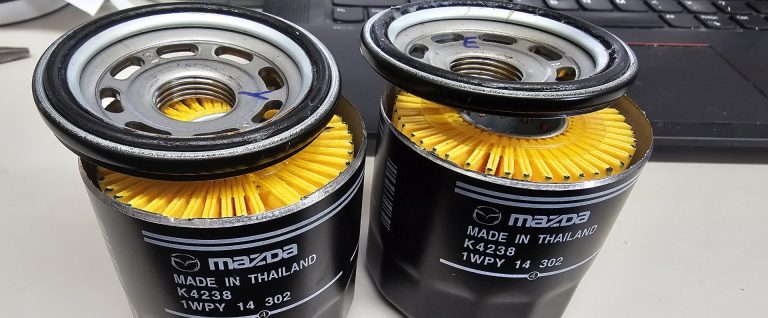 Two Mazda oil filters with the tops cut off.