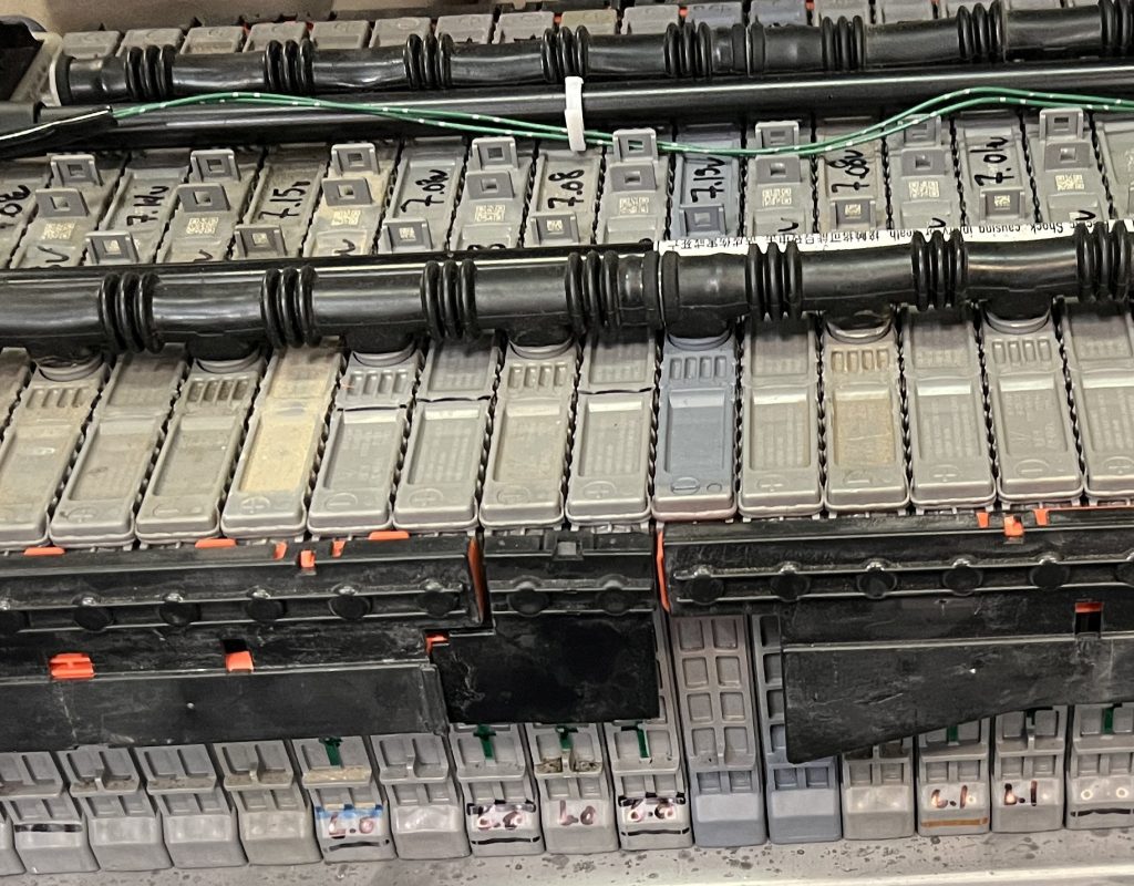 A rebuilt hybrid battery with mismatched cells and pen marks all over it.