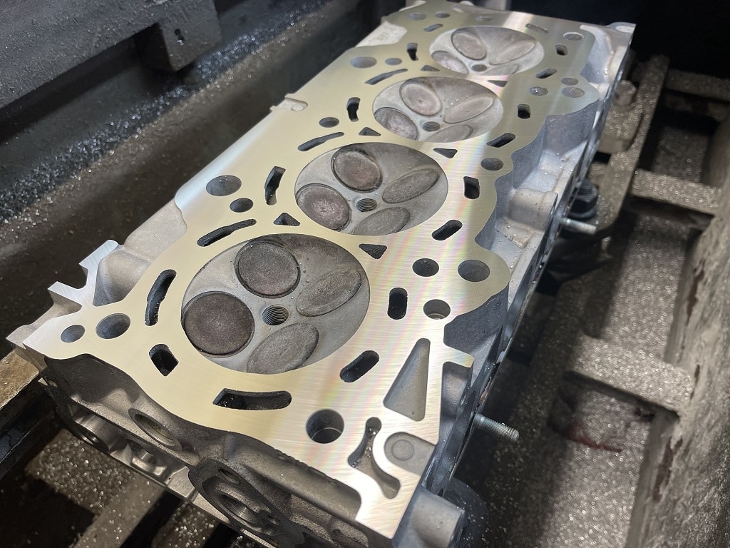 A cylinder head mounted to a resurfacing machine during an engine rebuild.