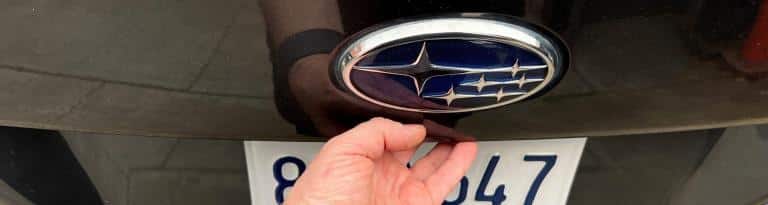 A hand pressing the rear hatch release button