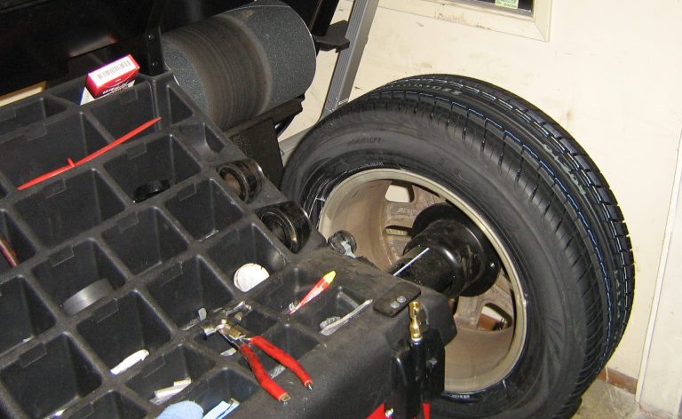 A tire balance machine with a new tire mounted.