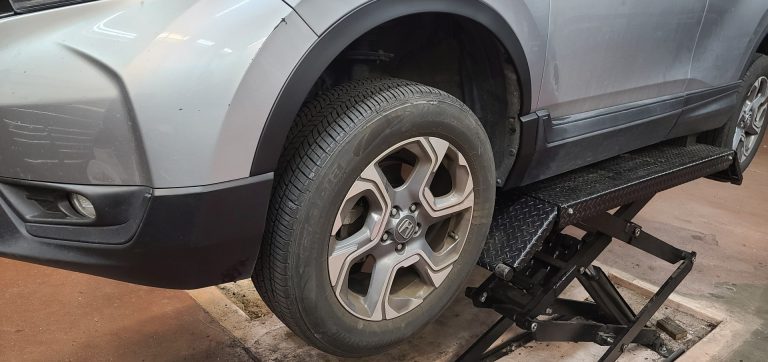 A car on a rack for tire rotation
