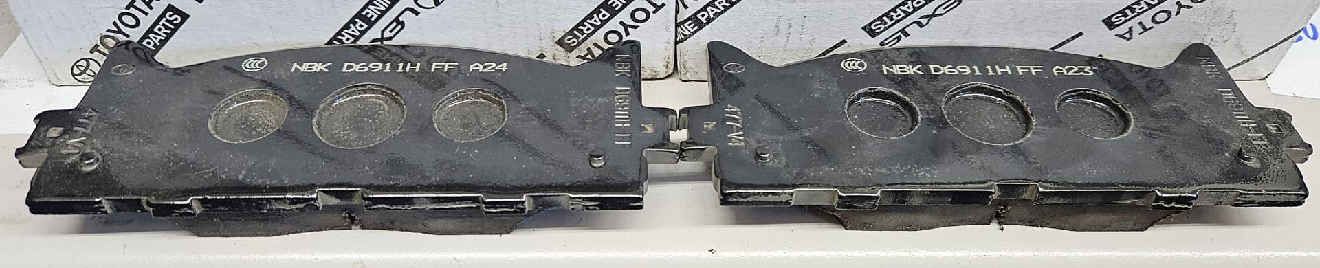 An image of two identical brake pads the only difference being a 24 being printed on one and a23 being printed on the other.