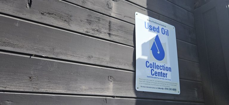 A used oil collection center sign on our shop's fence.