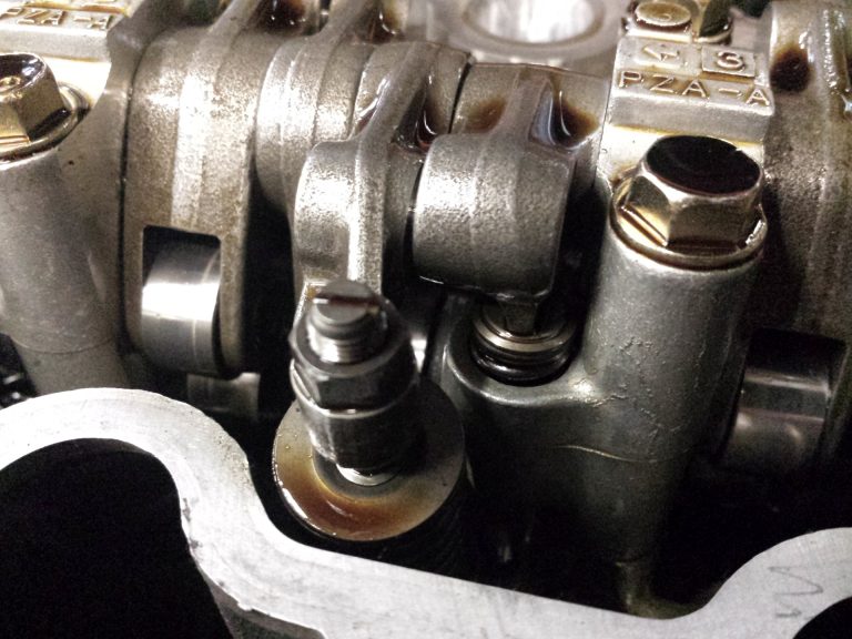 A close up of a screw and jam nut style valve adjustment