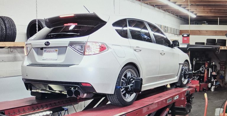 A Subaru on a wheel alignment rack