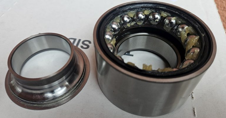 Need a partially disassembled wheel bearing sitting on a bench.