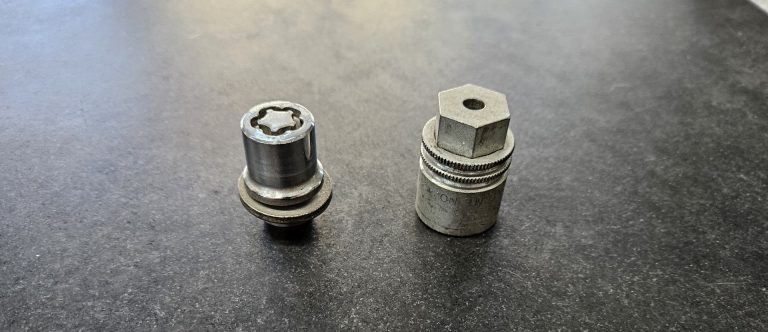 A locking lug nut and a wheel lock key sitting side by side.